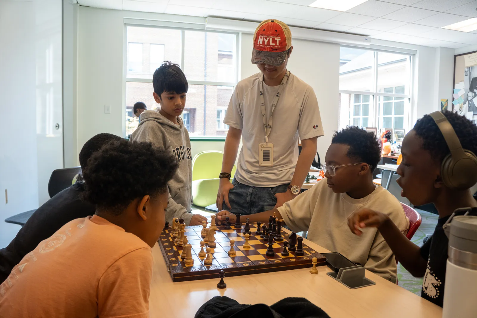 A Checkmate Your Summer coach walking a group of students through a position.